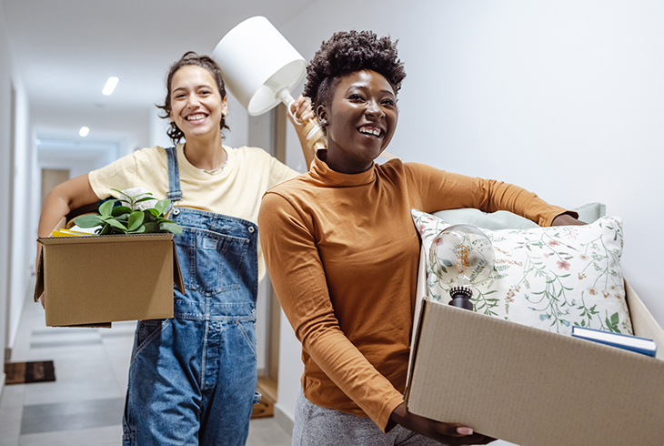 Two young adults caring moving boxes