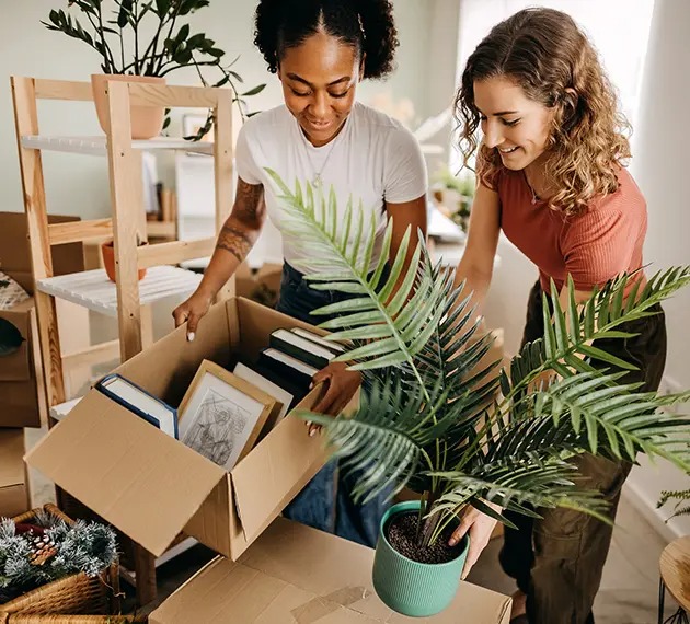 two young women packing moving boxes