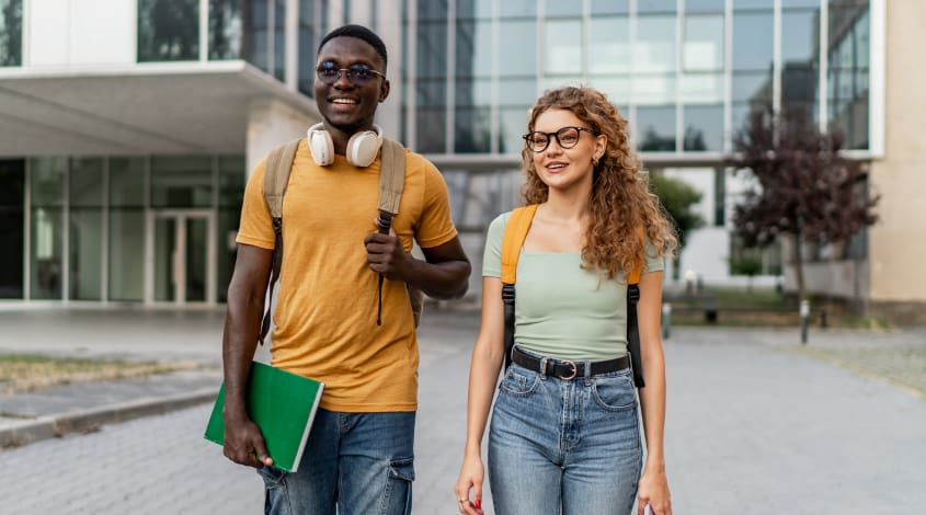two students standing outside of an academic building