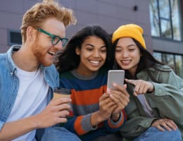 a diverse group of young adults looking at a smartphone