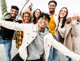 a diverse group of young adults smiling outside